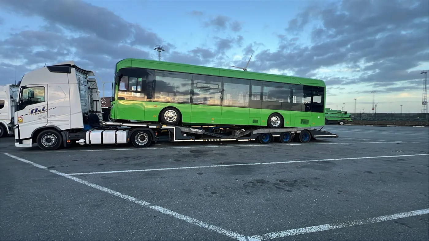 Autobuz electric verde pe semiremorca OL Speditionwagon, în Portul Anvers, Belgia, pentru transport la Compania de Transport Public Arad