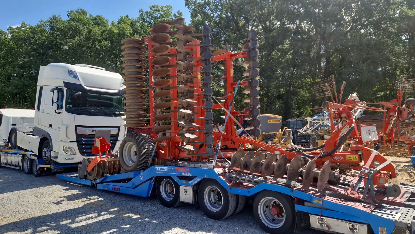 Vedere laterală: cap tractor DAF în zona din față a semiremorcii TRIAS și disc agricol KUHN în zona centrală și posterioară