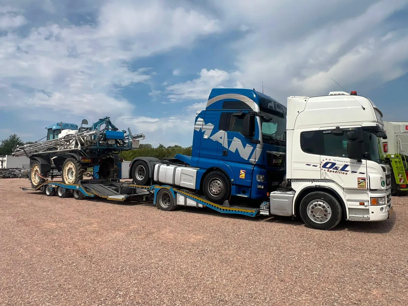 Cap tractor MAN TGX albastru și stropitoare agricolă Matrot încărcate pe platforma OL Speditionwagon pentru transport din Franța în România