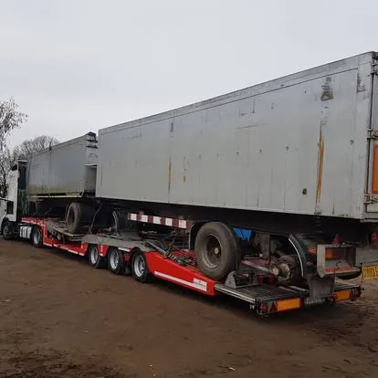 Semiremorcă basculantă lungă, încărcată pe trală pentru transport ca marfă. - OL Speditionwagon