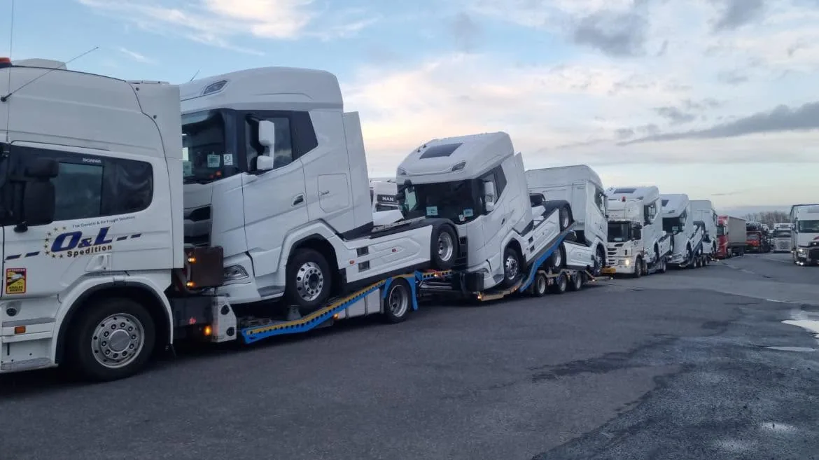 Flotă O&L, transport camioane premium pe trailere